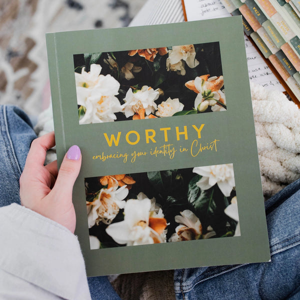 Woman holding the Worthy 4-week Bible study on identity in Christ, exploring titles of child, heir, slave, and saint, helping believers understand their true worth.