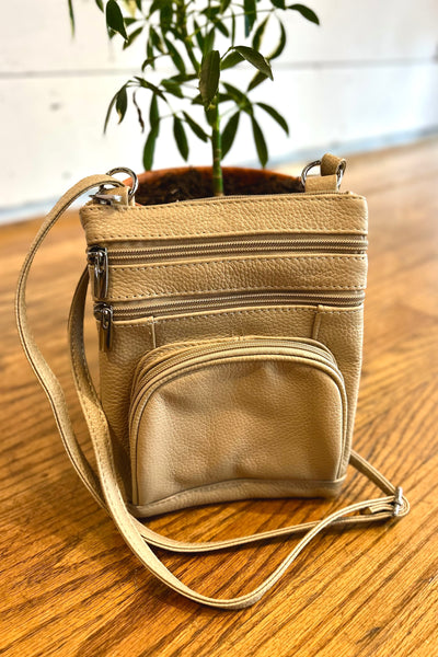 Cream leather crossbody bag with adjustable strap, multiple compartments, zippered pocket, card slots, and back phone pocket.