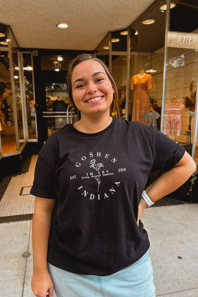 Black graphic tee featuring Goshen, Indiana 5-year I M SHE design, made of 100% ring-spun cotton, styled casually.