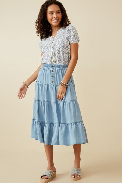 Woman wearing soft tencel tiered skirt with button detail and elastic waistband, styled for casual or dressy looks.