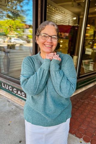 Woman wearing soft cozy long sleeve top in Ash Jade color. 