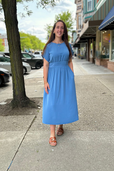 Ladies wearing a modest blue dress with cap sleeves walking on a sidewalk in Downtown. 