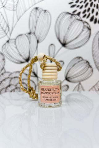 Grapefruit + Mangosteen car diffuser providing natural, long-lasting fragrance, paraben-free, creating a fresh and inviting atmosphere inside a vehicle.